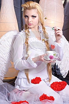 Young beauty girl angel holding a cup