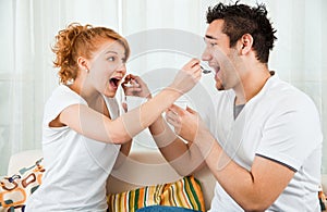 Young, beauty girl and boy eating yoghurt