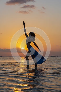 Young beauty girl dancing at tropical beach on sea water at paradise island at sunset. Summer concept