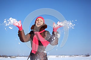 Young beauty girl outdoor in winter throws snow