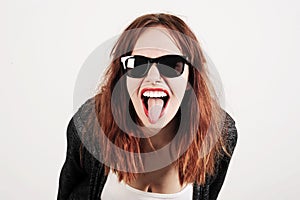 Young beauty hipster woman screaming and showing tongue, funny face with sunglasses