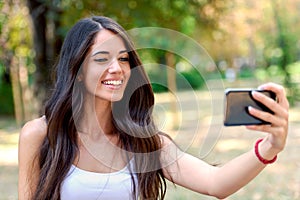 Young Beauty with long brown hair looking at smartphone