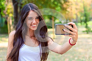 Young Beauty with long brown hair looking at smartphone