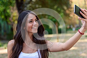 Young Beauty with long brown hair looking at smartphone