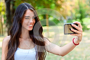 Young Beauty with long brown hair looking at smartphone