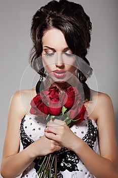 Young Beauty Smelling Bouquet of Red Roses. Pleasure & Harmony