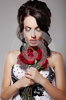 Young Beauty Smelling Bouquet of Red Roses. Pleasure & Harmony photo