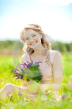 Young beauty smiling woman in the field, on the grass. Girl rest