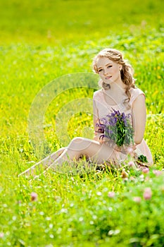 Young beauty smiling woman in the field, on the grass. Girl rest