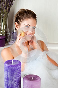 Young beauty woman in the bath washing her face