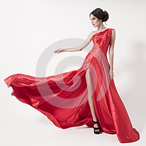 Young beauty woman in fluttering red dress. White background.