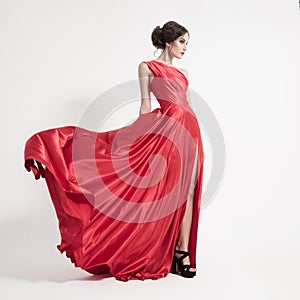 Young beauty woman in fluttering red dress. White background. photo