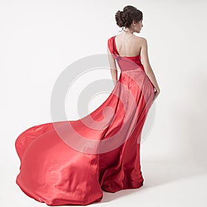 Young beauty woman in fluttering red dress. White background.