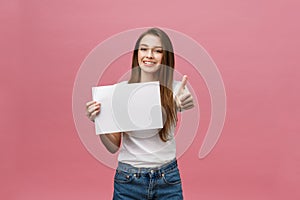 Young beauty woman hold blank card and showing thumbs up over pink background