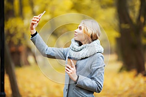 Young Beauty woman listening music in autumn forest