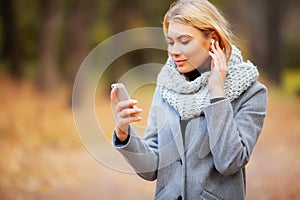 Young Beauty woman listening music in autumn forest