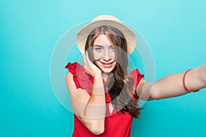 Young beauty woman in straw hat take sefie on blue background