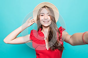 Young beauty woman in straw hat take sefie on blue background