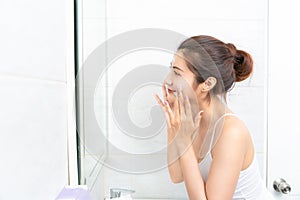 Young beauty woman washing her face in bathroom