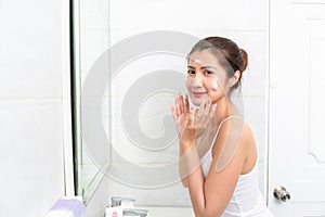 Young beauty woman washing her face in bathroom