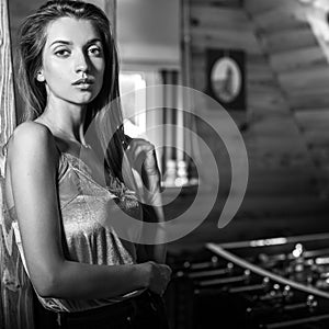 Young beauty woman in wooden house interior.