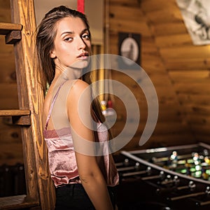 Young beauty woman in wooden house interior.