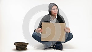 Young begging man with blank cardboard.