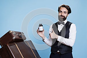 Young bellman holds bottle of drugs