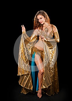 Young belly dancer posing in gold costume with Isis wings