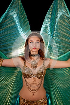 Young belly dancer posing with Isis wings