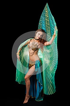 Young belly dancer posing with Isis wings