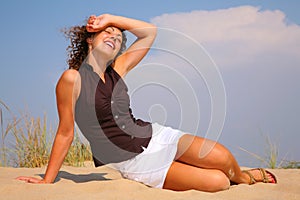 Young beuty woman sit on sand photo