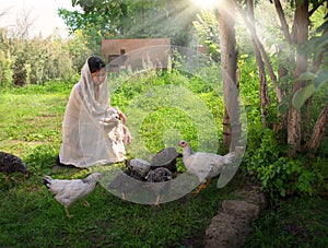 Girl feeding chickens in the garden