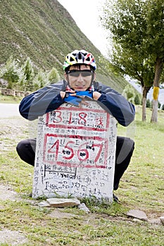 Young bicycle man at destination sign