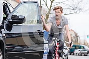 Young bicyclist shouting while swerving for avoiding dangerous collision