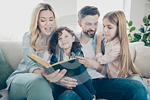 Young big family two children comfortable sitting sofa listening mommy reading favorite fairy tale