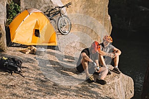 young bike travellers with canned food sitting