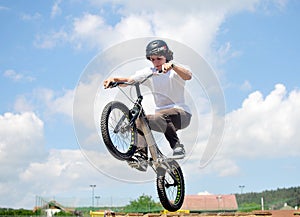 Young biker boy does tricks in the air