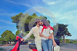 Young biker couple on the country road against the sky