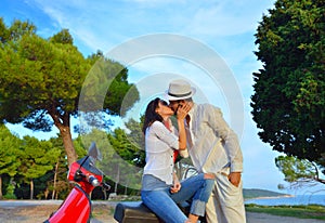 Young biker couple on the country road against the sky