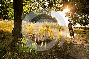 Young biker going fast downhill with dust raising