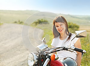 Young biker woman on the country road