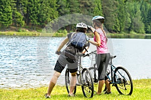 Young bikers at lake watching the forest