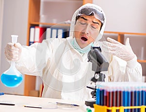 Young biochemist wearing protective suit working in the lab