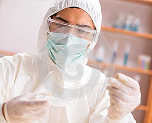 Young biochemist wearing protective suit working in the lab