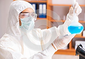 Young biochemist wearing protective suit working in the lab