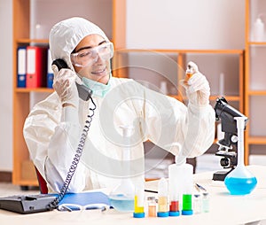 Young biochemist wearing protective suit working in the lab