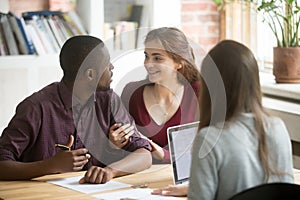 Young biracial diverse couple consulting before signing mortgage