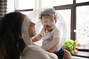 Young biracial mom play with smiling little baby girl