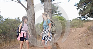 Young biracial woman and Caucasian woman chat during a hike in nature